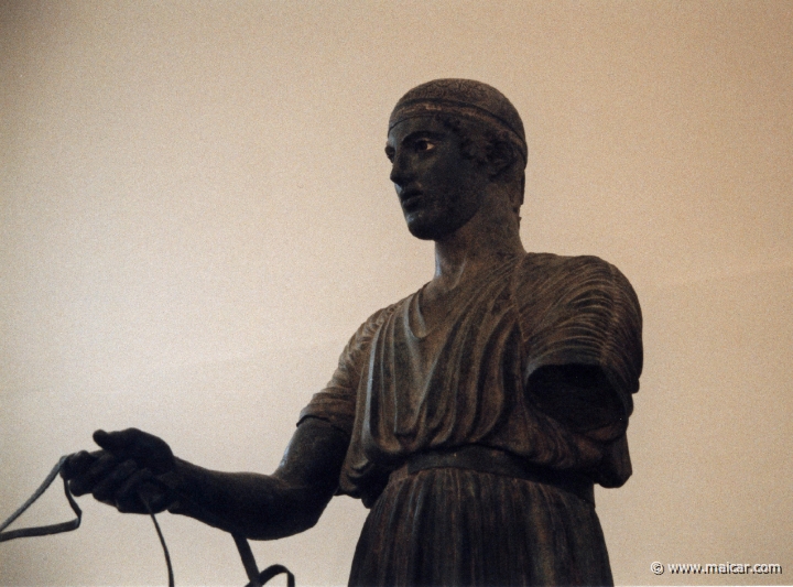6011.jpg - 6010: Bronze statue of a charioteer belonging to a quadriga. Dedication of the Syracusean Polyzalos, brother of the tyrants Gelo and Hiero. Masterpiece of an unknown artist (about 478 BC). Archaeological Museum, Delphi.