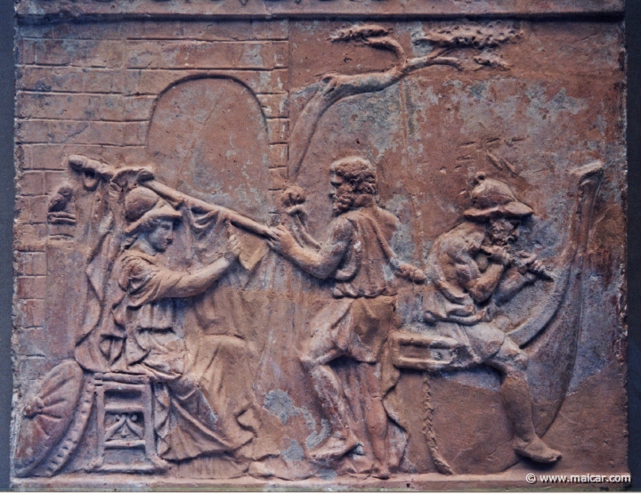 8037.jpg - 8037: Terracotta relief. Athena supervises the building of the ship Argo, c. 1st century AD. The yard is held by the helmsman Tiphys, Argos sits across the stern. British Museum, London.