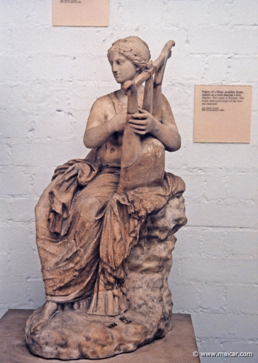 8031.jpg - 8031: Possibly Erato seated on a rock playing a lyre. Marble. British Museum, London.