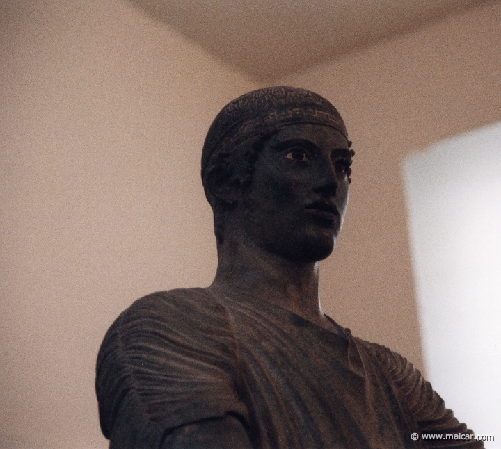 6015.jpg - 6015: Bronze statue of a charioteer belonging to a quadriga. Dedication of the Syracusean Polyzalos, brother of the tyrants Gelo and Hiero. Masterpiece of an unknown artist (about 478 BC). Archaeological Museum, Delphi.