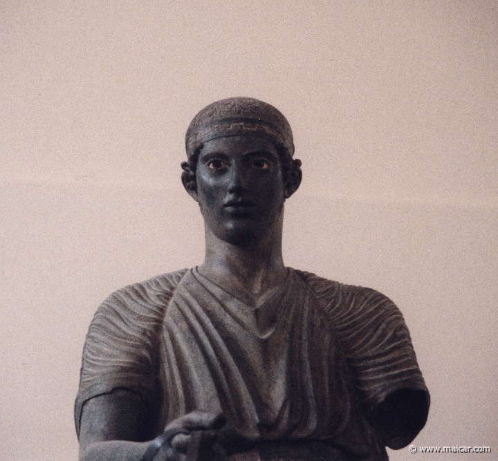 6036.jpg - 6036: Bronze statue of a charioteer belonging to a quadriga. Dedication of the Syracusean Polyzalos, brother of the tyrants Gelo and Hiero. Masterpiece of an unknown artist (about 478 BC). Archaeological Museum, Delphi.