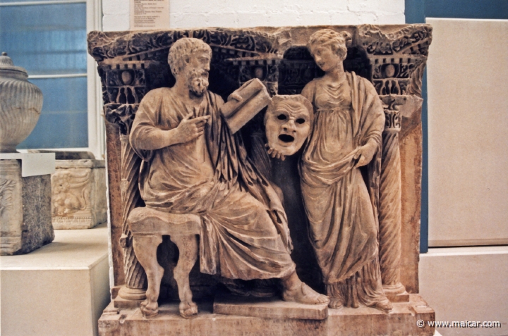 8015.jpg - 8015: Sarcophagus: a seated man reads from a scroll to Thalia, the Muse of Comedy. Phrygian marble. About AD 180-200. From the “gardens of Pompeii” near the Ghetto, Rome. British Museum, London.